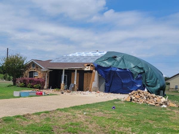 a tarp-covered home damaged by the Salado tornado