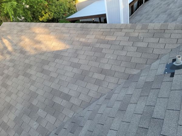 hail damage marked in chalk, warranting a storm restoration roofing replacement