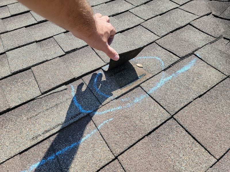 roof damage circled in chalk, potentially substantiating an insurance claim